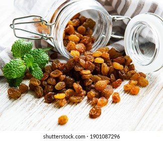 Yellow golden raisins on a white wooden background
