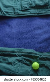 Yellow Golf Ball On Open Green Jacket With Blue Lining, Like A Ball Lying At The Edge Of A Water Hazard On A Golf Course