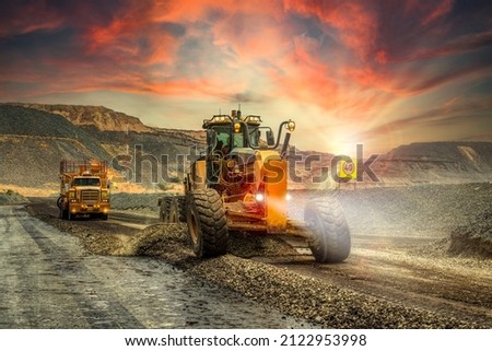 yellow grader digging the earth on a construction site at a diamond mine