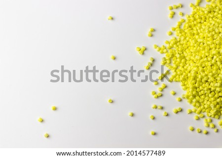 Yellow granules of polypropylene or polyamide on a white background. Plastics and polymers industry. Copy space