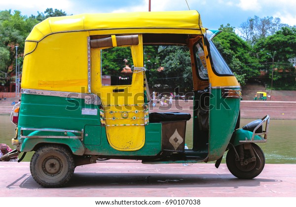 Yellow and green auto rickshaw\
