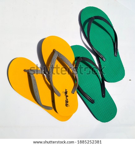 Yellow and green flip flops isolated on white background