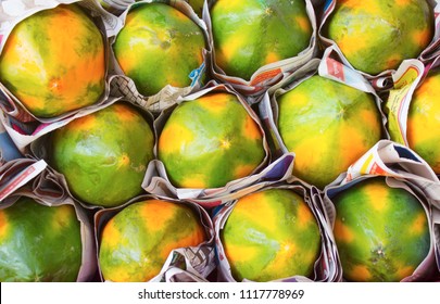 Yellow And Green Papaya Wrapped In Paper