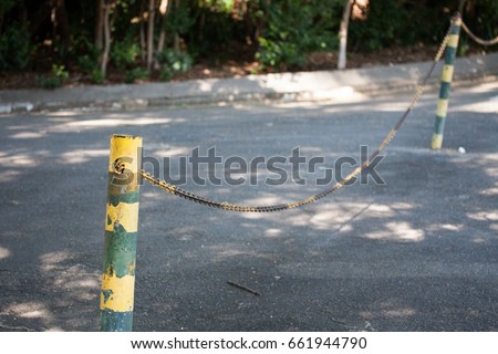 Yellow and green poles with protective chain