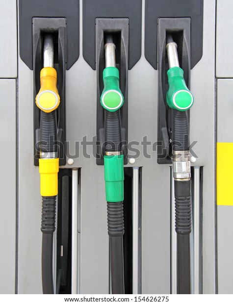 Yellow and\
green Pump nozzles at the gas\
station