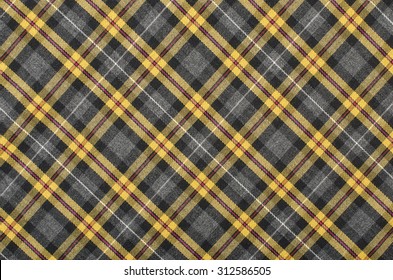 Yellow with grey and black plaid print as background. Scottish tartan pattern. Symmetric rhombus pattern.