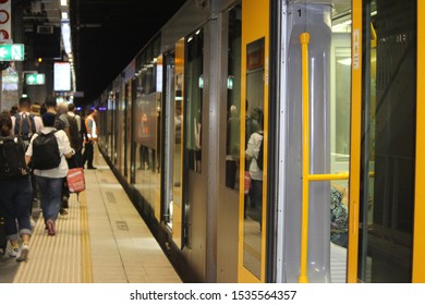 Yellow And Grey Train With Its Doors Open On A Crowded Platform In An Underground Tunnel. Sydney