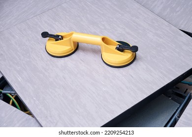 Yellow Handheld Device With Vacuum Suction Cups For Lifting Floor Panels