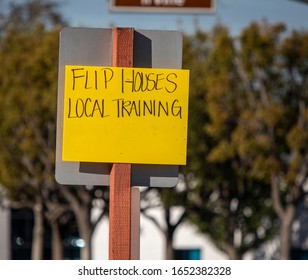 Yellow Handwritten Sign Recruiting For Get Rich Quick By Flipping Houses At Intersection