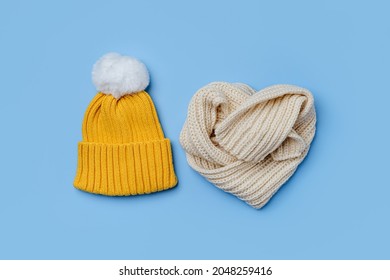 Yellow hat and scarf on blue background. Stylish childrens outerwear. Winter fashion outfit 