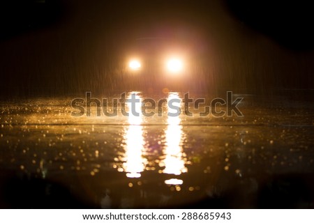 Yellow headlight and road in the dark while heavy raining.