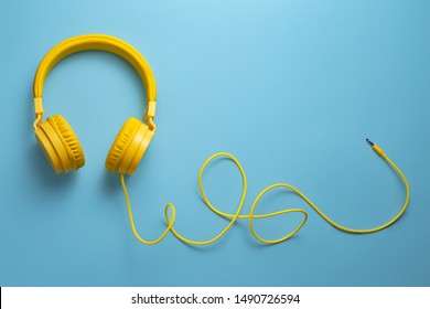 Yellow headphones on blue background. Music concept. - Shutterstock ID 1490726594