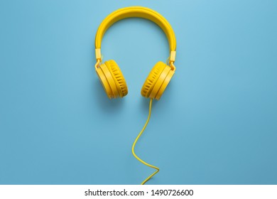 Yellow headphones on blue background. Music concept. - Shutterstock ID 1490726600