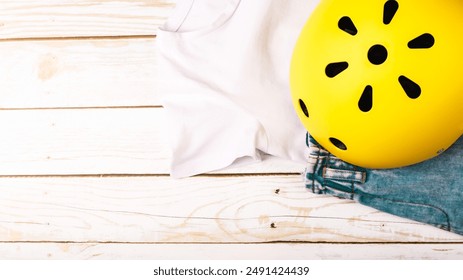 Yellow helmet on wooden background. Child's outdoors activity safety protection: rollers, bicycle, skateboard - Powered by Shutterstock