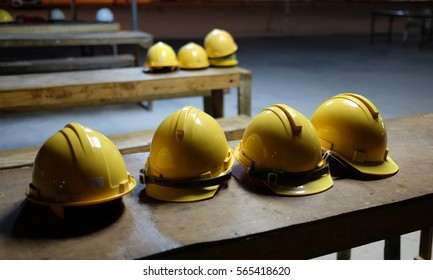  Yellow helmets of worker and engineer put on the wood table in construction site