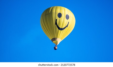 A yellow hot air balloon in the blue sky