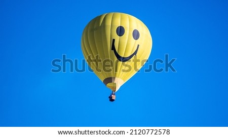 A yellow hot air balloon in the blue sky