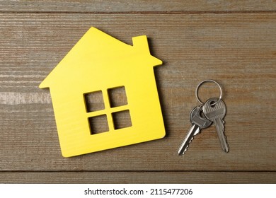 Yellow House Model And Keys On Wooden Table, Flat Lay. Housewarming Party