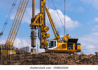 Yellow Hydraulic Drilling Rig On A High-rise Building Construction Site. Installing A Bored Piles With A Casing String. Foundation Skyscraper