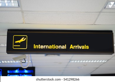 Yellow illuminated sign at airport with  Arrival information board sign