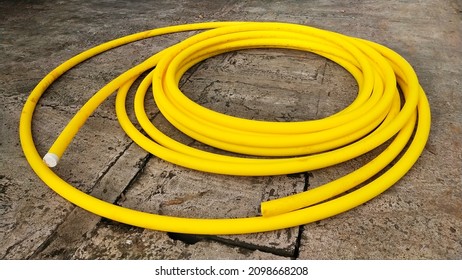 Yellow Industrial Optical Cable Roll. Shielded In A Plastic Enclosure. Will Be Put Underground Or Trench At A Construction Site.