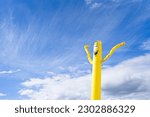 Yellow Inflatable Doll Blowing Wind with happy face.