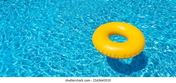 Yellow inflatable ring floating in swimming pool. Vacation concept with copy space - Powered by Shutterstock