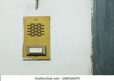 Yellow intercom on a white wall, with empty name tag suitable for adding text