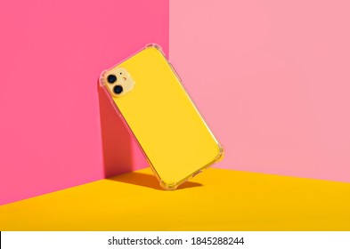 Yellow iPhone 11 in clear phone case, bright and colorful phone case mock up 
