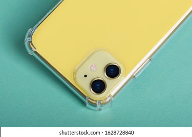 Yellow IPhone 11 Isolated On Yellow Background Close Up. Smartphone In Clear Silicone Case, Phone Case Mock Up