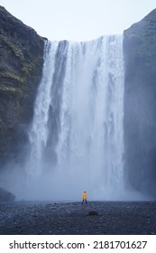 Yellow Jacket Man With A Waterfall Behind Him