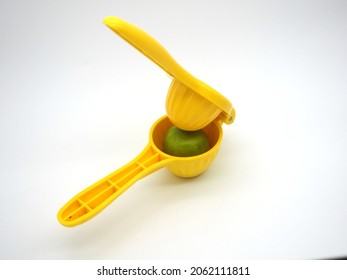 Yellow Juicer With Green Lemon. Manual Citrus Press Isolated On White Background. Close Up. Copy Space.