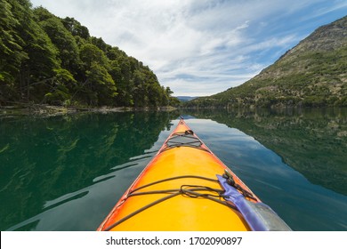 yellow kayak on a calm lake. Mountains and clouds. First person point of view. San Martín de los Andes, Patagonia, Argentina