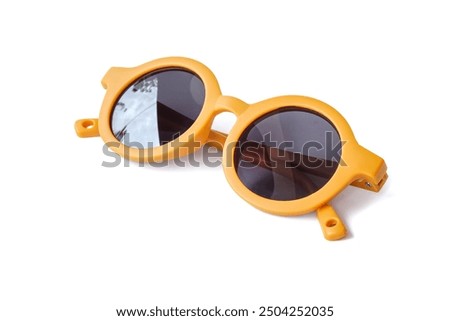 Yellow kids sunglasses close up on white background.