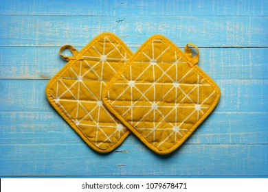 Yellow Kitchen Pot Holders On Blue Table - Closeup