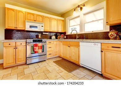 Yellow Kitchen With Wood Cabinets And Dark Brown Backsplash Design, Tile Floor And Small Rug