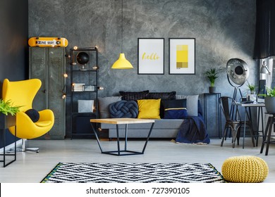 Yellow Lamp Above Table In Living Room With Grey Sofa, Yellow Pouf And Designer Chair