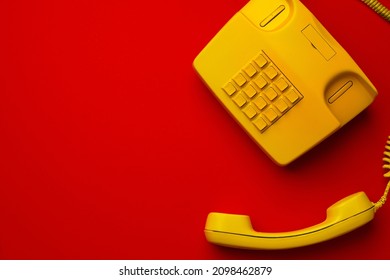 Yellow Landline Phone On Red Background Top View