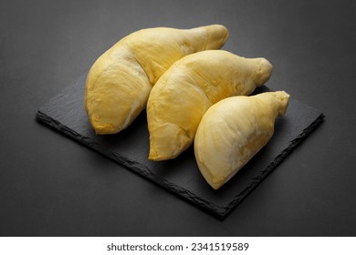 yellow Lava Durian Sisaket flesh on black slate and dark tone texture background, king of fruit, one of the most expensive fruit - Shutterstock ID 2341519589