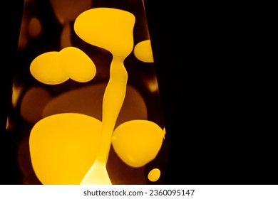 Yellow lava lamp, black background, horizontal format with copy space - Powered by Shutterstock - Get 15% off with code: PIKWIZARD15