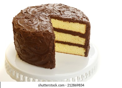 Yellow Layer Cake With Chocolate Icing With One Slice Missing.