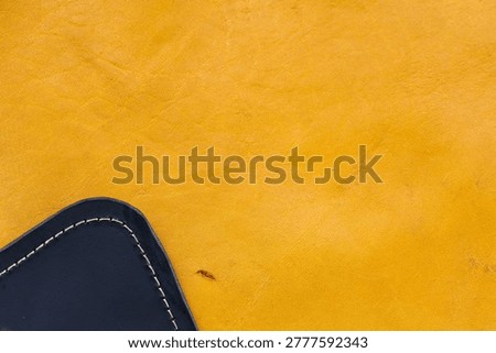 Yellow Leather Surface Texture Background with Navy Blue Stitched Leather Corner Detail