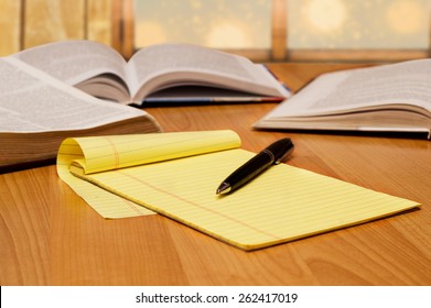 Yellow Legal Pad On The Table With Books