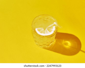 Yellow lemonade on solid background with soda and lemon. Close-up view