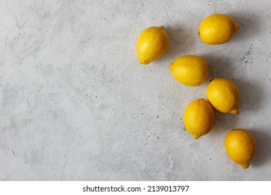Yellow lemons on the gray background. Top view flatlay with the copyspace.