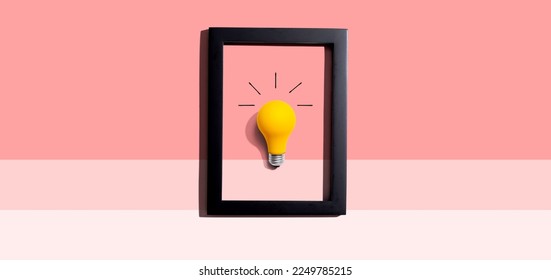 Yellow light bulb inside a frame - inspiration, creativity, energy, electricity themes