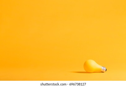 Yellow light bulb on a yellow background minimalist style - Powered by Shutterstock