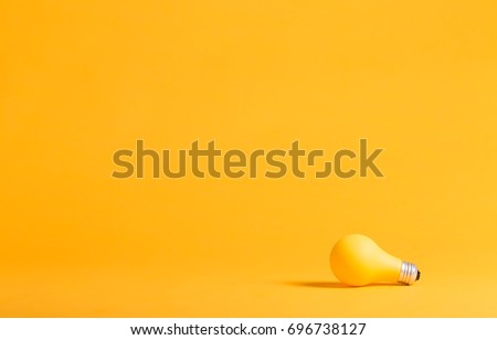 Yellow light bulb on a yellow background minimalist style