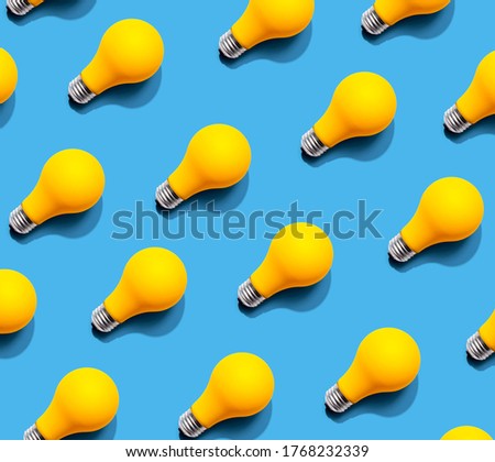 Yellow light bulb pattern with shadow - flat lay