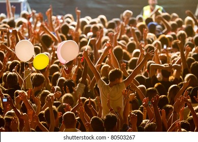 yellow lighted arded crowd at a live concert of a famous rockband - Shutterstock ID 80503267